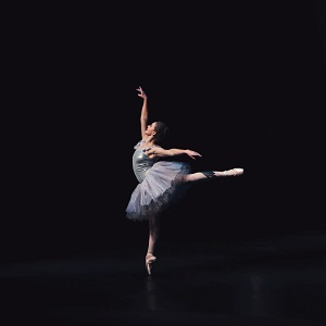 a ballerina standing at one foot with her arms and legs extending outwards in a stunning way.