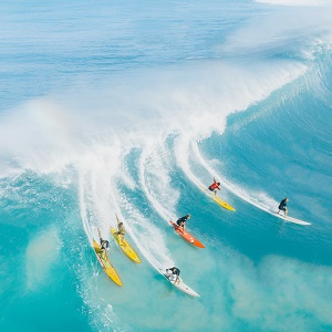 a group of people surfing during high tide.