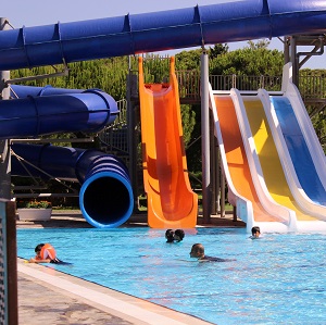 people enjoying in the pool near water slides.