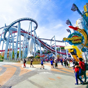 an image showing entrance view of the theme park where people are moving about.